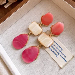 Vue détaillée de boucles d'oreilles vintage en résine avec d'élégantes bordures dorées