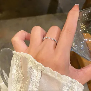 Close-up of a silver-colored dainty star open ring with sparkling zircons on a hand