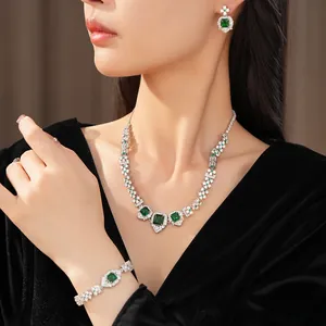 Gros plan élégant d'une parure vintage en zircon vert émeraude portée par un mannequin.