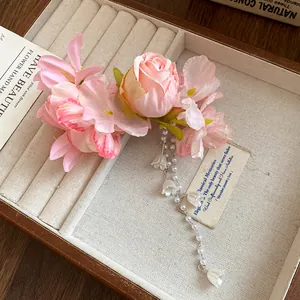 Dettaglio del fermaglio per capelli a fiori rosa con eleganti nappe di perle.