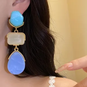 Gros plan détaillé de boucles d'oreilles vintage en résine avec texture marbrée dorée
