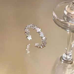 Detailed macro view of a silver open ring featuring alternating star and zircon designs