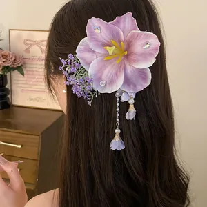 Dettaglio ravvicinato di una grande clip per capelli a fiore viola con nappe di perle