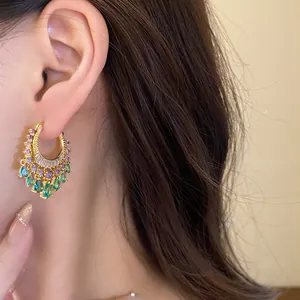 Detail view of elegant gold hoop earrings with colorful zircon waterdrop dangles
