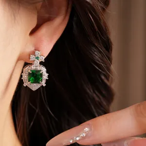 Détail d'une boucle d'oreille élégante en zircon vert émeraude portée par le modèle