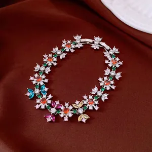Detail view of a vintage flower zircon bracelet with colorful stones on brown silk.