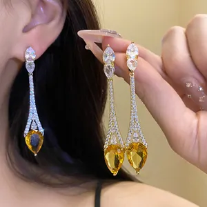Gros plan sur des boucles d'oreilles plaquées or 18k avec gouttes en zircon jaune étincelantes