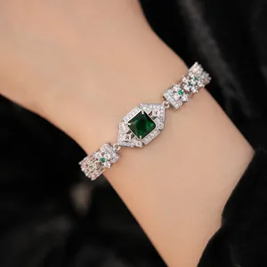Détail d'un bracelet élégant en argent avec zircon vert émeraude sur le poignet