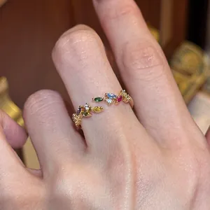 Detailaufnahme eines zierlichen goldenen Weizenährenrings mit bunten, funkelnden Edelsteinen
