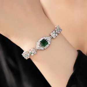 Gros plan d'un bracelet en argent vintage avec un grand zircon carré vert émeraude.