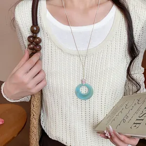 Primo piano di un elegante ciondolo circolare in acrilico turchese su collana