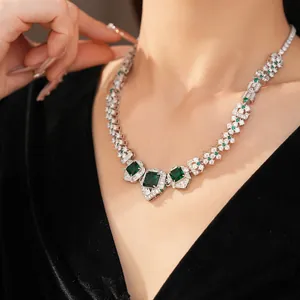 Détail d'un collier vintage argenté avec des zircons verts carrés sur un modèle