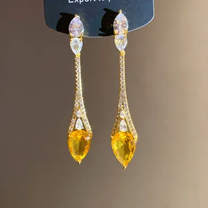 Gros-plan de boucles d'oreilles goutte d'eau plaquées or 18k avec zircons jaunes
