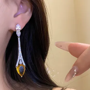 Vue détaillée de boucles d'oreilles pendantes en zircon jaune plaqué or 18k sur modèle