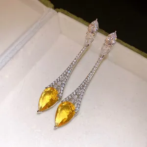 Gros plan détaillé de boucles d'oreilles en argent plaqué or 18k avec zircon jaune goutte d'eau