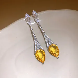 Gros plan détaillé de boucles d'oreilles pendantes en zircon jaune en forme de poire