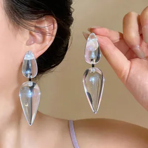 Detailed view of oversized transparent resin drop earrings with silver needles