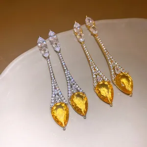 Vue détaillée de boucles d'oreilles goutte dorées 18 carats avec zircone jaune