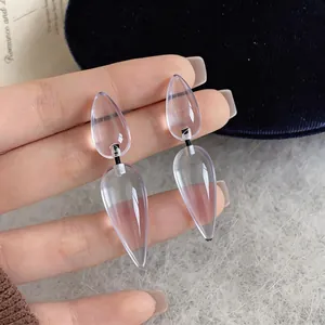 Close-up of transparent resin teardrop earrings with a minimalist double-segment design