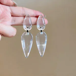 Detail showing the transparent texture of exaggerated water-drop resin earrings.