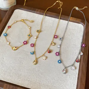 Detail view of vintage jewelry set featuring zircon flower and ladybug necklaces and bracelet