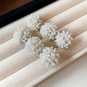 Exquisite French-style white beaded pearl hair clips set on a soft beige velvet jewelry tray