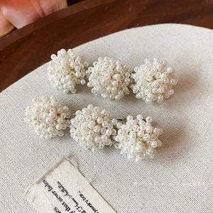 French style hair clips with beaded pearl clusters on beige textured background