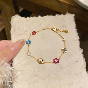 Detailed view of a gold-colored vintage bracelet with colorful enamel flower and ladybug charms.