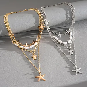 Detailed view of gold and silver layered necklaces with starfish and turtle charms