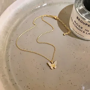 18k gold plated butterfly pendant necklace with sparkling cubic zirconia on a plate