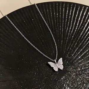 Elegant 18k gold plated butterfly pendant necklace with sparkling zircons on black dish
