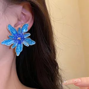 Large blue enamel flower stud earrings with a vintage vacation aesthetic