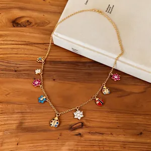 Detailed view of the colorful ladybug and floral charms on a gold-plated vintage necklace.