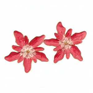 Red and white floral enamel stud earrings with gold accents on a white background