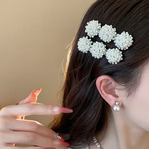 Detail view of elegant pearl cluster hair clips worn on side hair