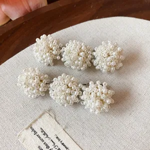 A detailed view of elegant white pearl bead clusters on French style duckbill hair clips.