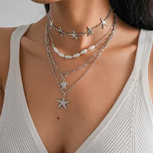 Close-up of four-piece layered necklace with starfish, turtle, and pearl details
