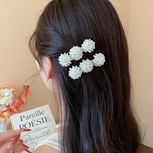 Detailed macro view showing elegant French pearl cluster hair clips styled on model dark hair