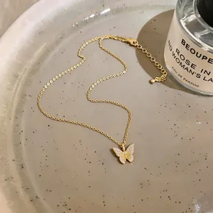 Close-up detail of a 18k gold plated butterfly pendant necklace with shiny cubic zircons.