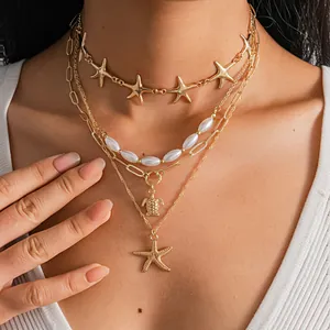 Detailed close-up view of a four-piece layered necklace set featuring starfish and turtle pendants