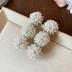 Detailed macro view of elegant clusters of white pearls on French duckbill hair clips