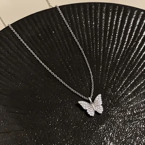 Close-up of sparkling zircon butterfly pendant on 18k gold plated necklace chain