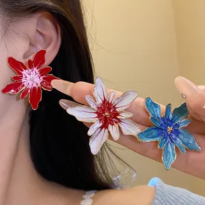Detailed view of colorful enamel floral stud earrings in red white and blue finishes