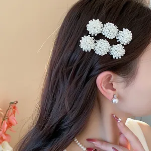 Detailed shot of elegant French style pearl cluster hair clips on a female model