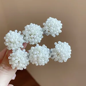 Close-up of elegant French style hair clips featuring intricate white pearl bead clusters
