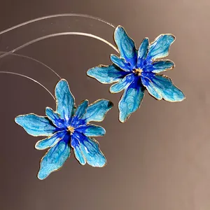 Elegant blue enamel flower stud earrings with shimmering gold-tone edges macro detail