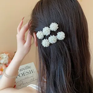 Close-up detail shot of French style white pearl hair clips worn on brunette hair for styling
