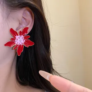 Close-up shot of a model wearing a large red and white drip oil floral stud earring