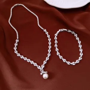 Elegant silver-toned zircon jewelry set with a pearl necklace and matching bracelet