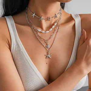 Detailed view of layered necklace set featuring starfish, turtle pendants and pearls